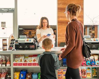 mother and sun at shop checkout with display of confectionery